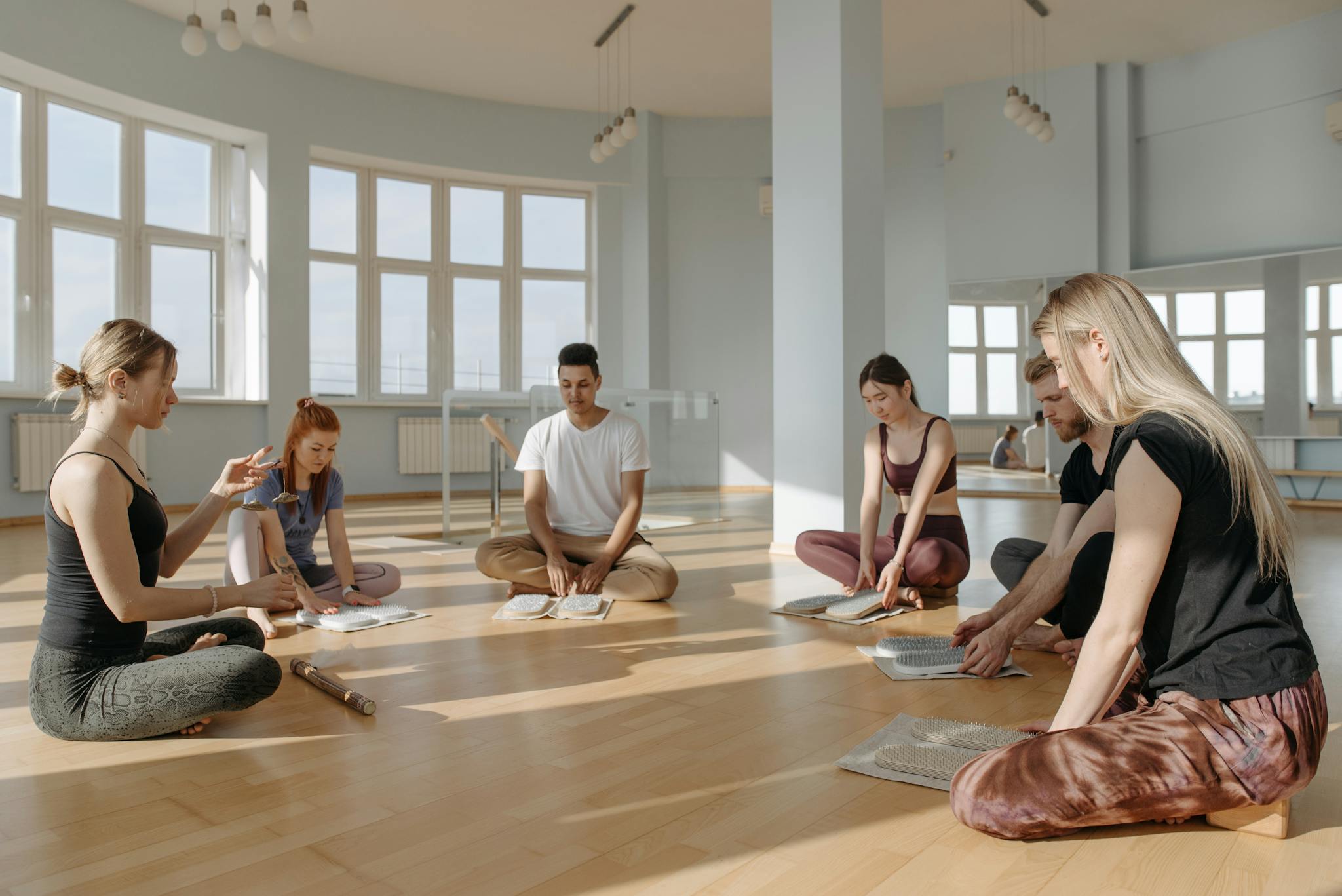 A diverse group of people meditating together indoors, creating a serene and peaceful environment.