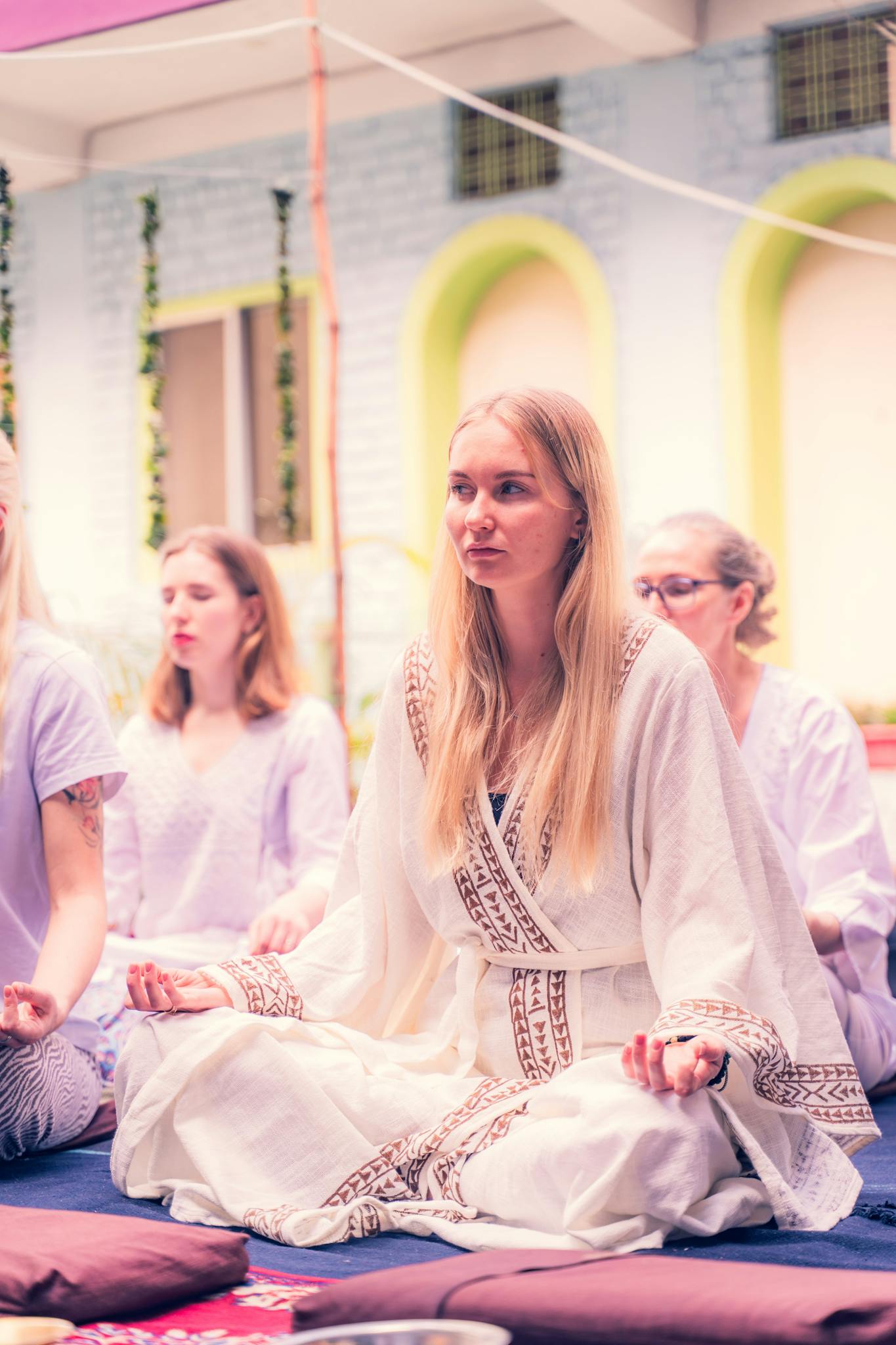 Group of women in serene meditation session outdoors, exuding calm and relaxation.
