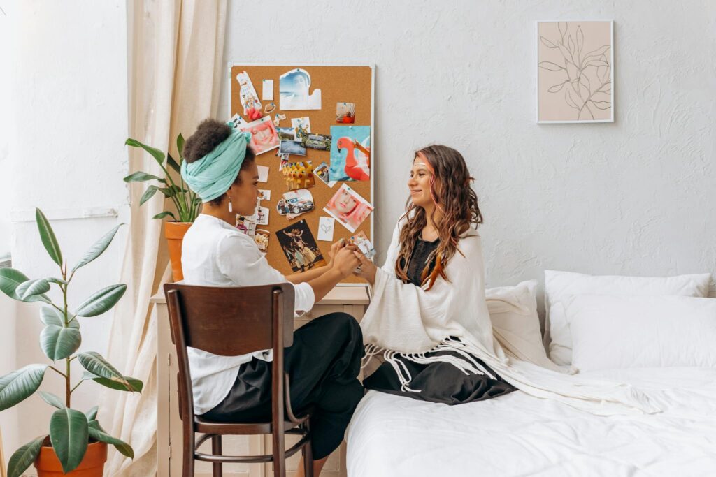 Two women sharing a mindful and spiritual moment in a cozy, indoor setting, promoting wellness and connection.